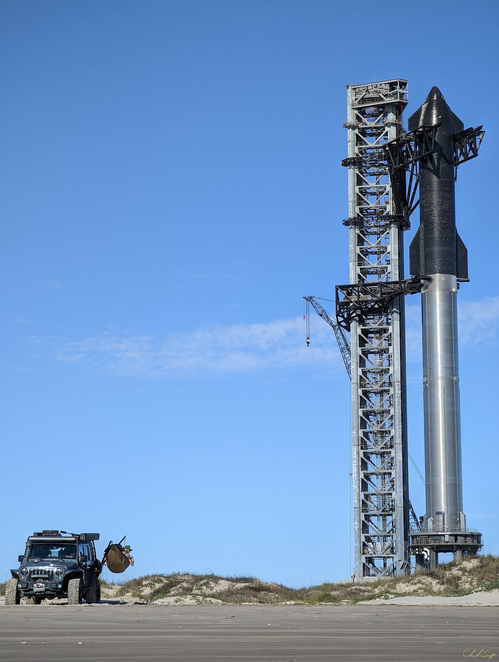 SpaceX's Starship (Starship SN20 and Super Heavy BN4) fully stacked at SpaceX Starbase in Boca Chica, Texas with a Jeep in the foreground for scale.